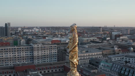 AERIAL:-Golden-Statue,-Sculpture-Close-up-on-Church-Cathedral-Rooftop-in-Berlin,-Germany,-Europe-at-Dusk