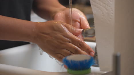 Mujer-Afroamericana-Enjuagando-Jabón-De-Sus-Manos-En-El-Fregadero-De-La-Cocina---Aislado-De-Cerca