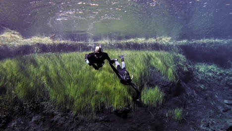 professional snorkeler helps a diver to ascend.