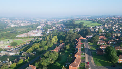 dewsbury moore council estate, uk, is captured by a drone, highlighting red-brick homes and the industrial yorkshire scenery on a sunny summer morning