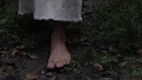 Closeup-of-robed-man-or-Jesus-walking-through-forest-trees