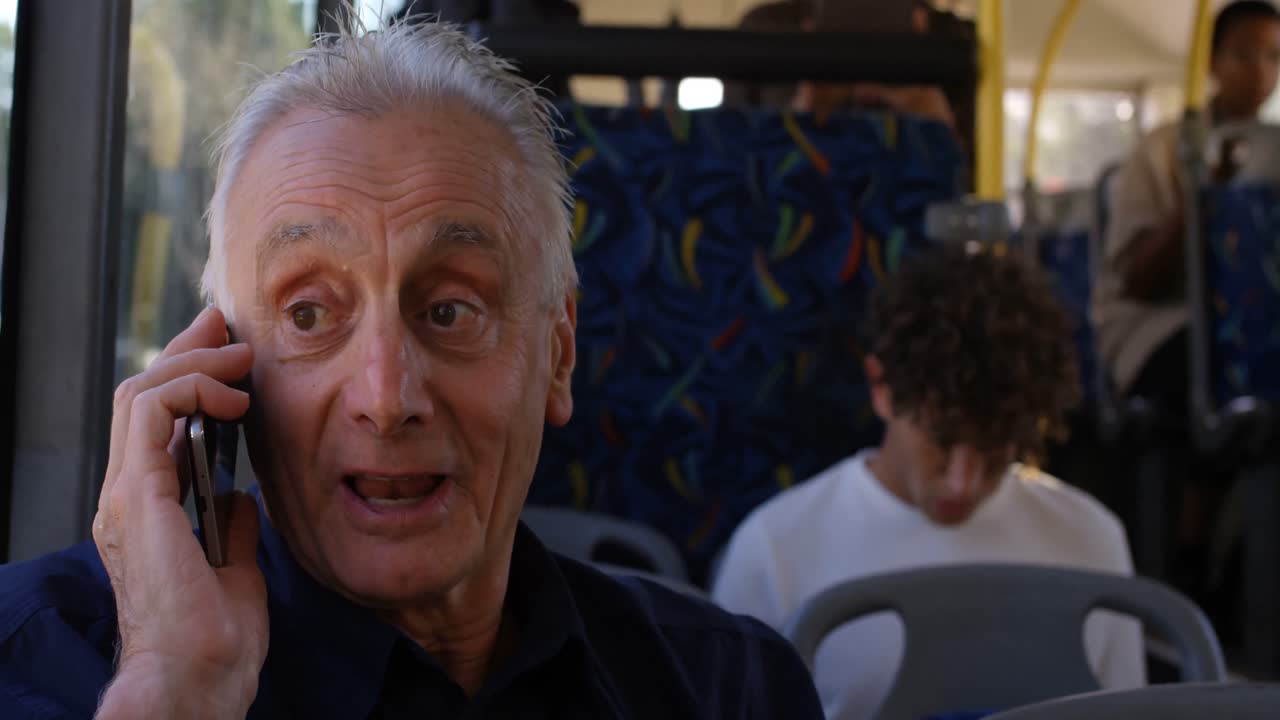 버스 4k에서 여행하는 동안  ⁇ 드폰으로 이야기하는 노인