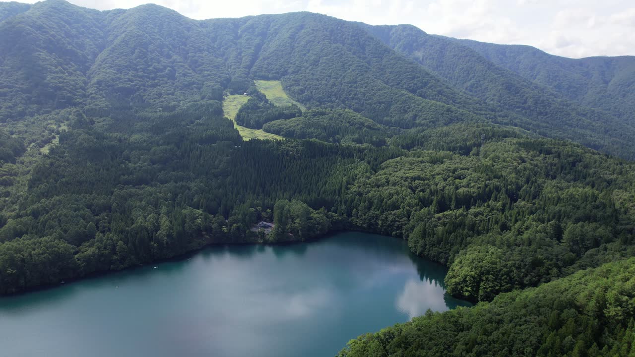 Mountain Range Covered With Lush Green Forests At Lake Aoki Near Omachi, Nagano Prefecture In Japan. Aerial Drone Shot