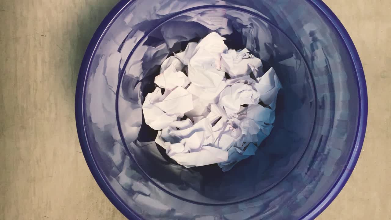 사무실의 쓰레기통에 종이를 던지다