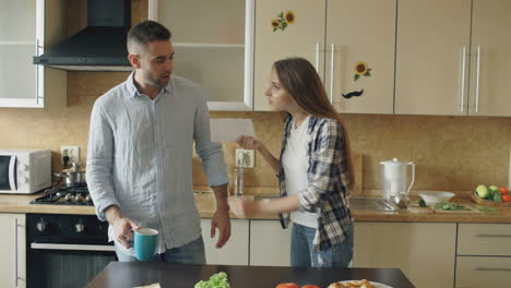 una pareja discutiendo en la cocina.