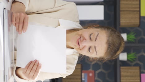 vertical video of business woman rejoicing at positive paperwork results.