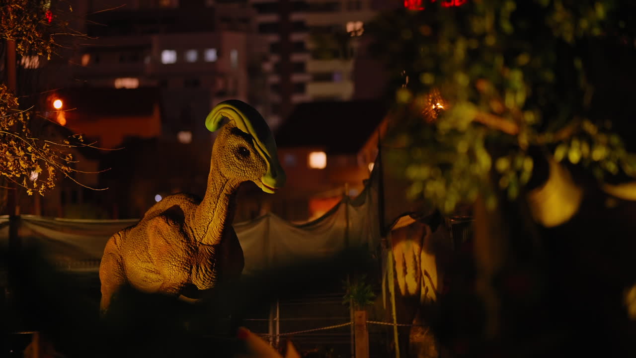 밤에 테마파크를 돌아다니는 볏이 있는 초식 공룡의 로봇