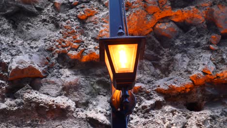 a street lamp on a stone wall at night