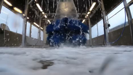 a peak moment in an automated car wash, showcasing the dynamic action of water and brush equipment effectively cleaning a vehicle's surface.