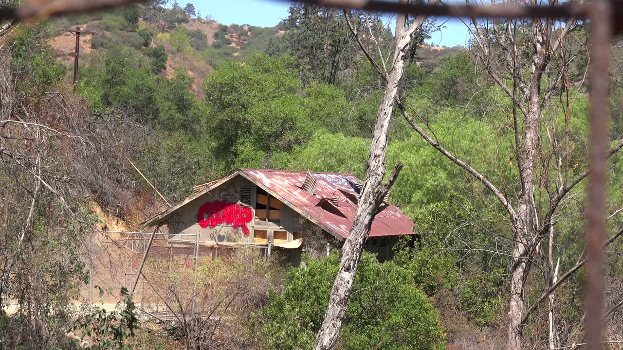 una cabaña deteriorada y aterradora en las colinas se ve desde la distancia 1