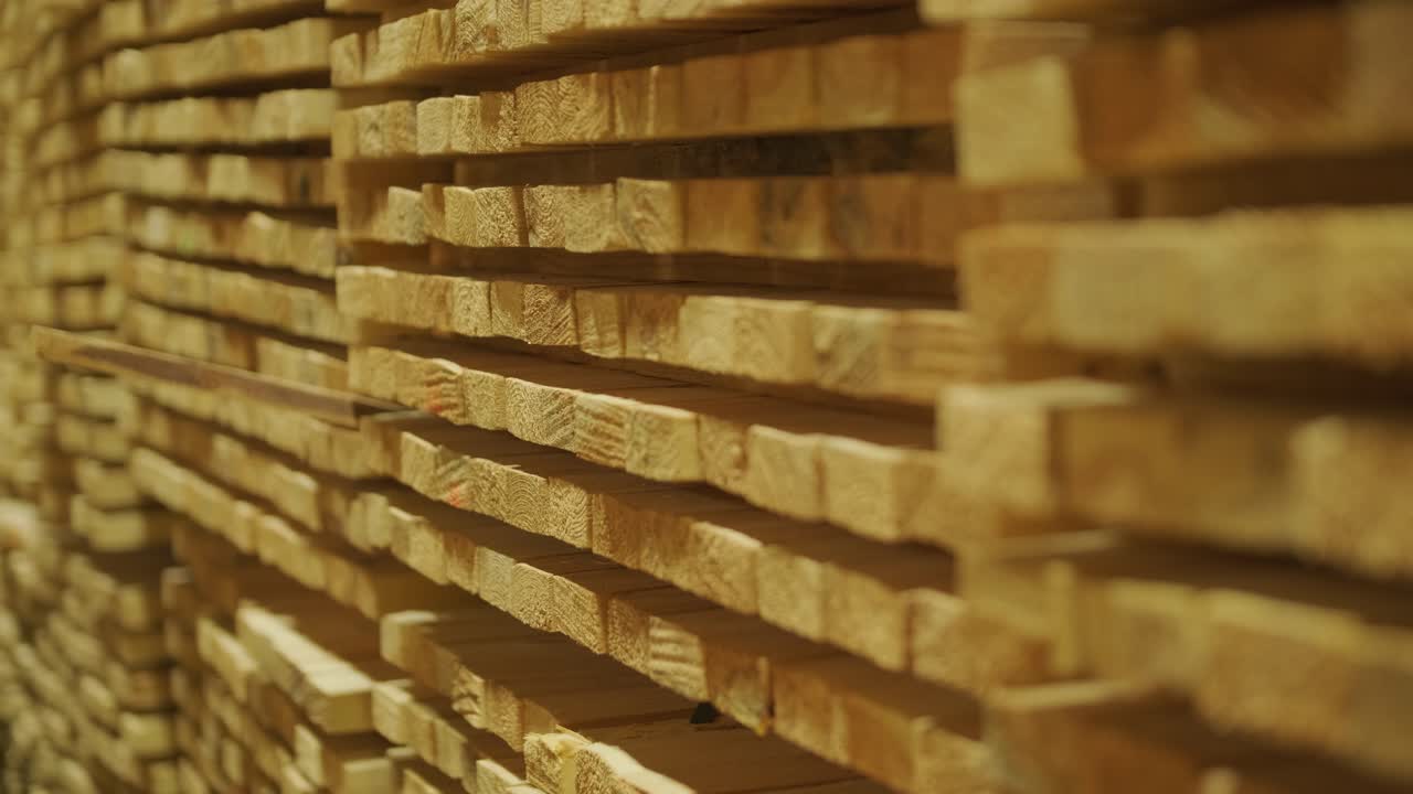Primo piano di assi di legno impilate ordinatamente in un magazzino di legname.