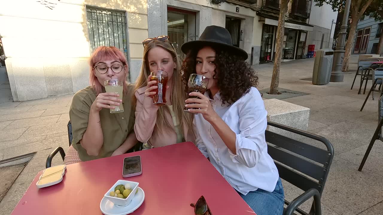 Three women enjoying drinks at an outdoor table