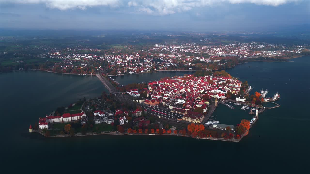 Obersee Bodensee fall autumn leaf golden hour sunset clouds Landau Germany Switzerland aerial drone view island shoreline marina sailboat ferries train European lake Constance backwards upwards
