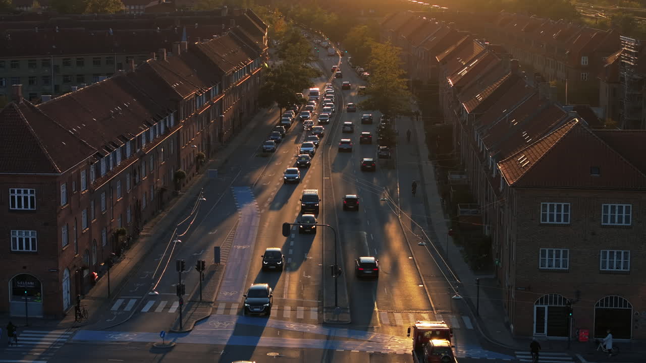 Aerial drone view of cars moving on the streets of Vesterbro district in Copenhagen, Denmark at sunset