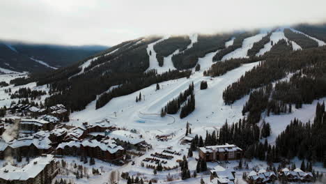 fog lift cloud layer winter snowy early morning sunrise aerial drone copper mountain colorado ski resort i70 eagle flyer lift center village snowboarding half pipe ikon pass parking lot forward pan up