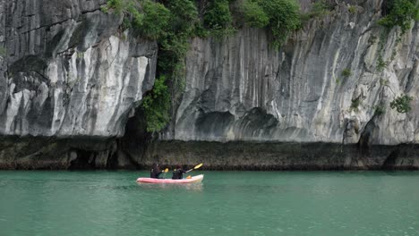 kayaking in halong bay with rocky cliffs in the background in vietnam