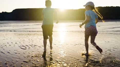 niños corriendo en la playa al atardecer