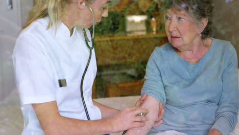 médico comprobando el pulso de una mujer mayor usando un estetoscopio en la cama 4k