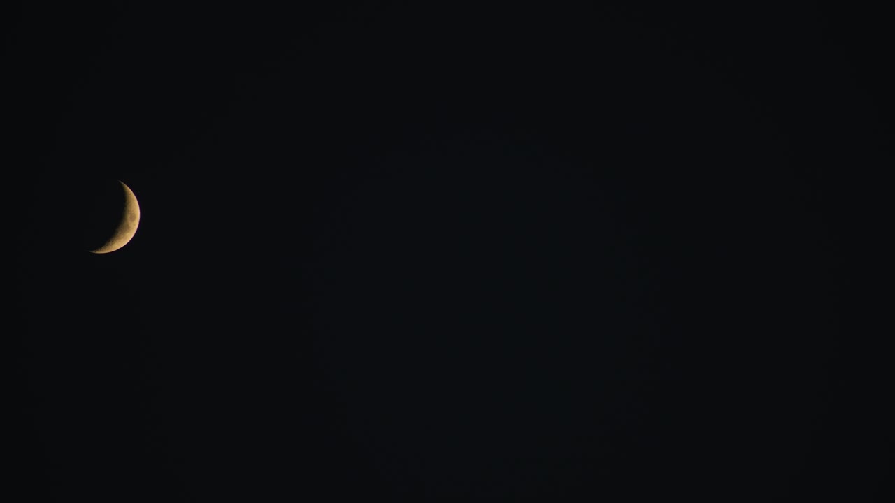 luna creciente en el cielo nocturno viajando de izquierda a derecha