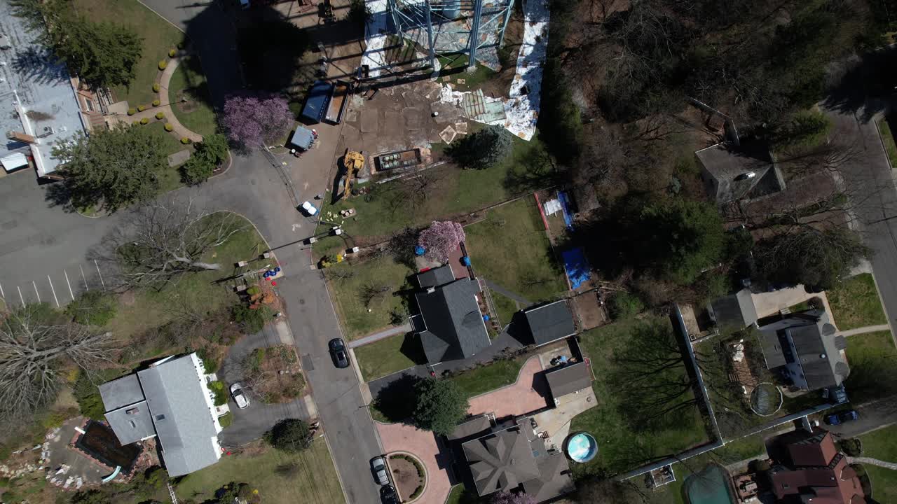 una vista aérea de arriba hacia abajo de una torre de agua siendo desmantelada en un día soleado en long island, nueva york