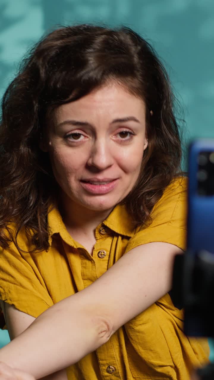 Giovane donna che saluta ed esprime emozioni allo smartphone