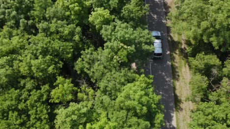 Arial-shot-of-a-car-rolling-through-the-forest