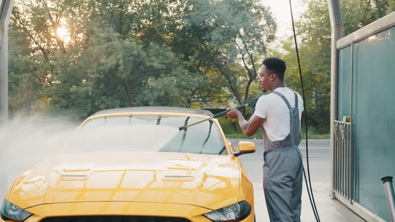 차 세탁장에서 노란색 컨버터블 차를 는 남자