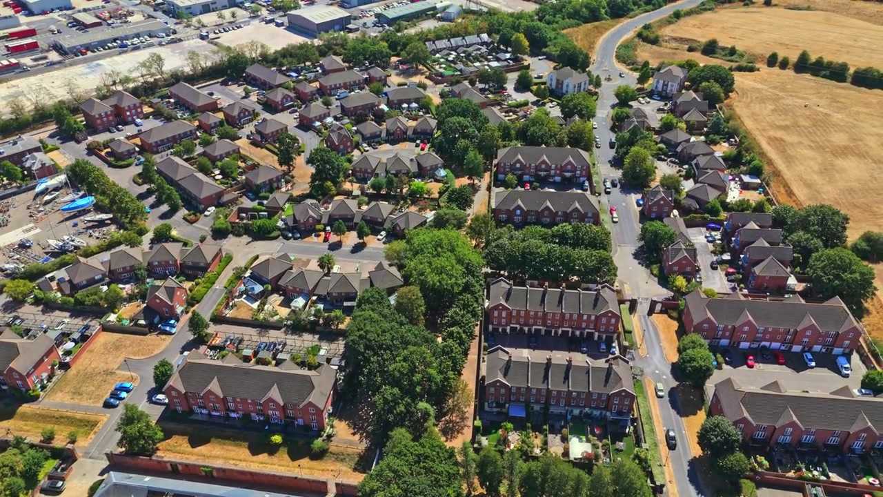Marchwood er en landsby i Hampshire ved Southampton Water nær New Forest, med boligområder, lokale bådeværfter og en stor militærhavn på en solrig sommerdag med tørt græs.