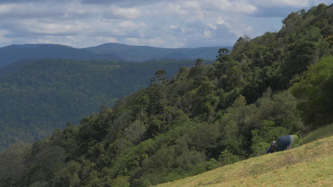 preparando paracaídas para volar en parapente sobre las montañas del parque nacional lamington, australia