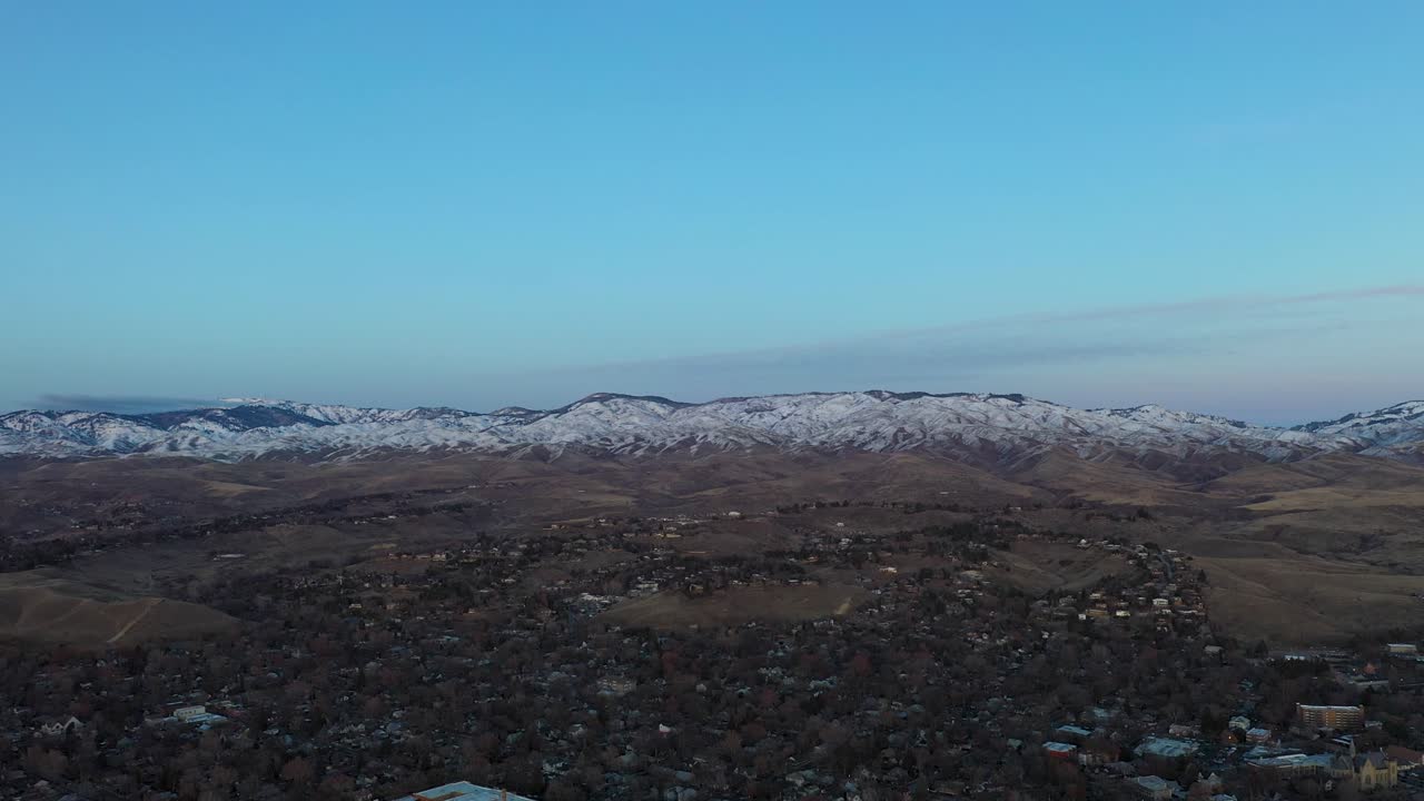 Morning drone shot over Boise, Idaho with snow capped mountains in the background