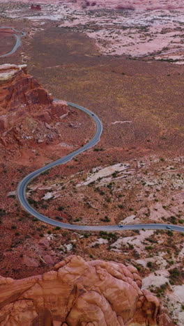 curvy road going round the majestic rocks of utah national park. amazing canyons and deserted lands from aerial perspective. vertical video