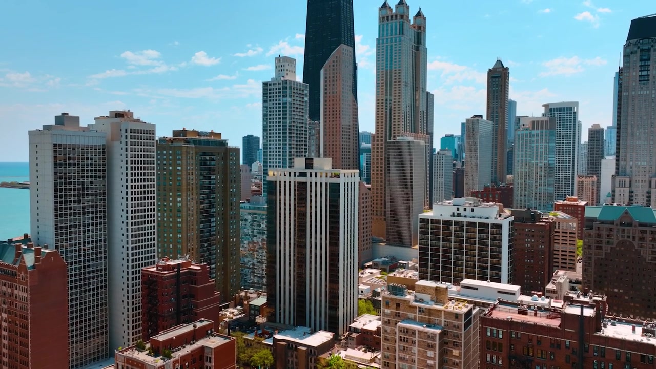 Volo sopra i condomini a più piani avvicinandosi ai grattacieli sullo sfondo. Il variegato centro di Chicago, Illinois, USA.