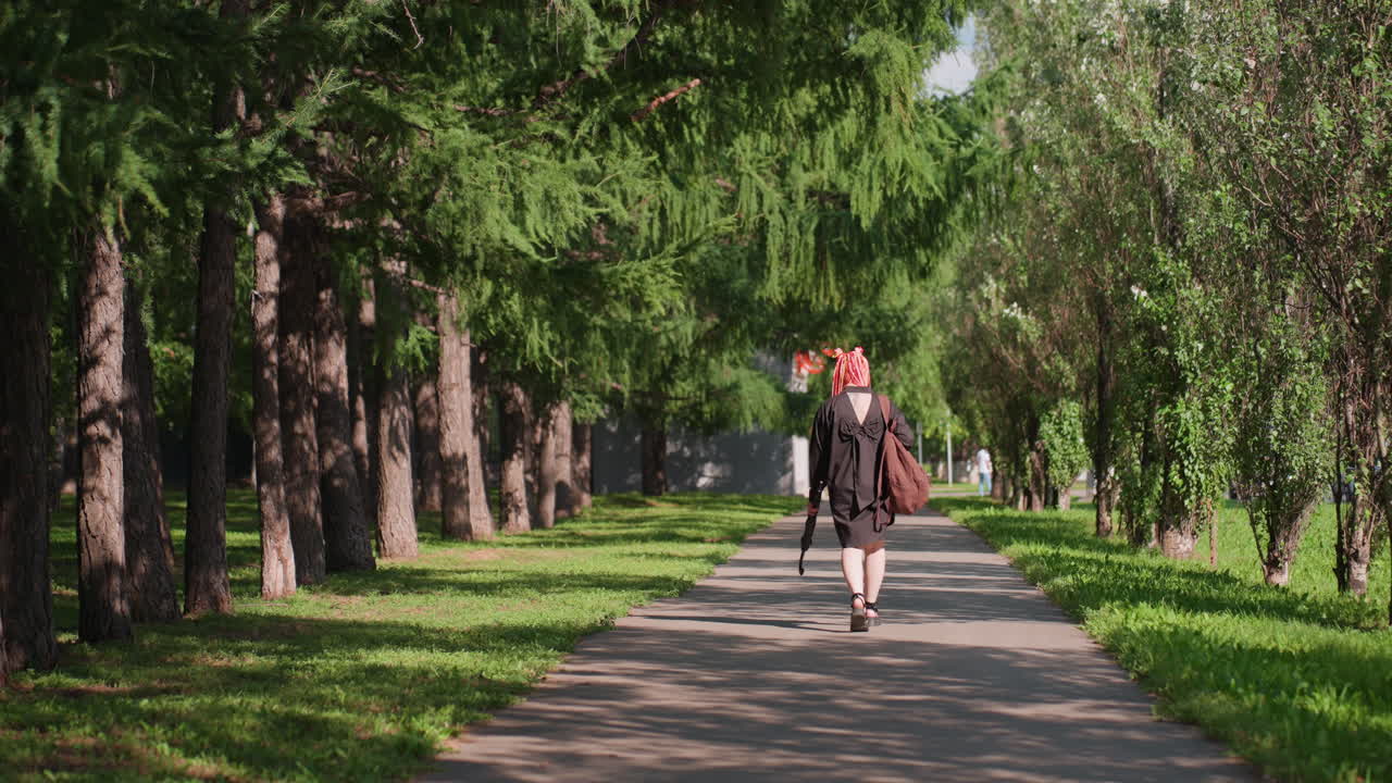 Un viajero recorre feliz un tranquilo sendero arbolado, un aventurero descubre la naturaleza vibrante durante un paseo tranquilo, un explorador se deleita con la exuberante vegetación y el relajante paisaje estacional en un sendero tranquilo