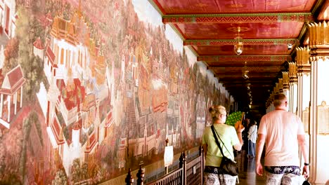 visitors admire temple wall paintings in bangkok