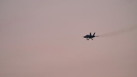 f-18 fighter jet with extended landing gear flying at dusk slomo track