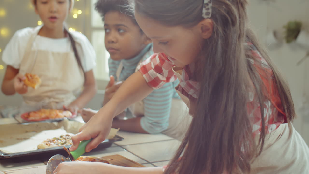 요리 마스터 클래스에서 피자를 자르는 소녀