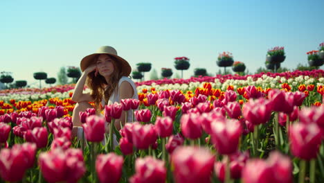 Entspannte-Frau-Sitzt-Im-Schönen-Frühlingsgarten.-Blick-Auf-Das-Blühende-Tulpenfeld.