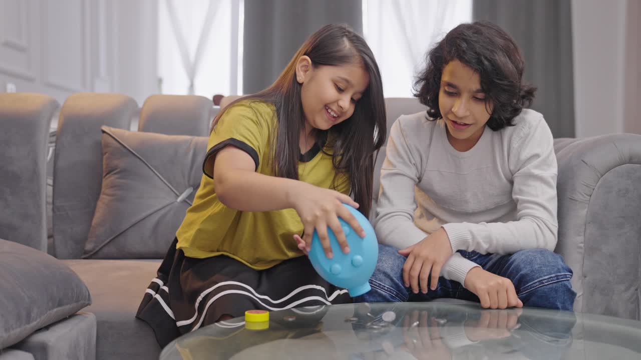 los hermanos indios se decepcionan después de ver algunas monedas en la alcancía.