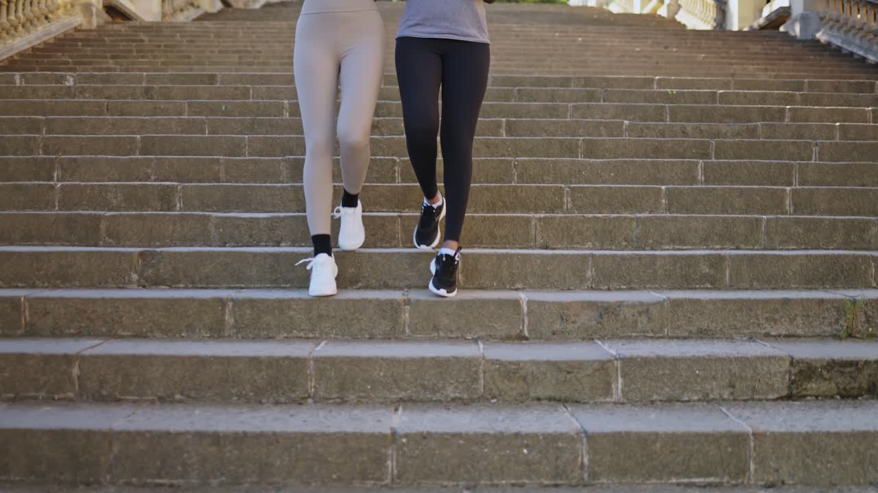 Due donne che scendono delle scale di pietra durante un esercizio all'aperto