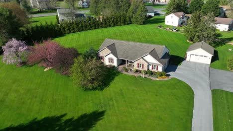 aerial top down shot luxury mansion with large green garden and colorful trees in sun