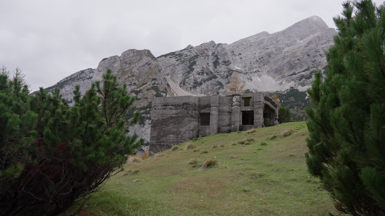 Una vista cinematográfica panorámica de los dramáticos picos de piedra caliza y las sinuosas carreteras de montaña del Paso Vršič en Eslovenia, capturando la escarpada belleza natural de los Alpes Julianos durante un claro día de otoño.
