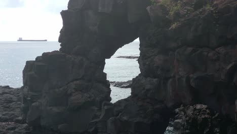 mauritius - albion - fixed view on the stone arch with a boat in the background