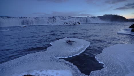 faxafoss waterfall - frozen water flowing at faxi waterfall at dusk in iceland