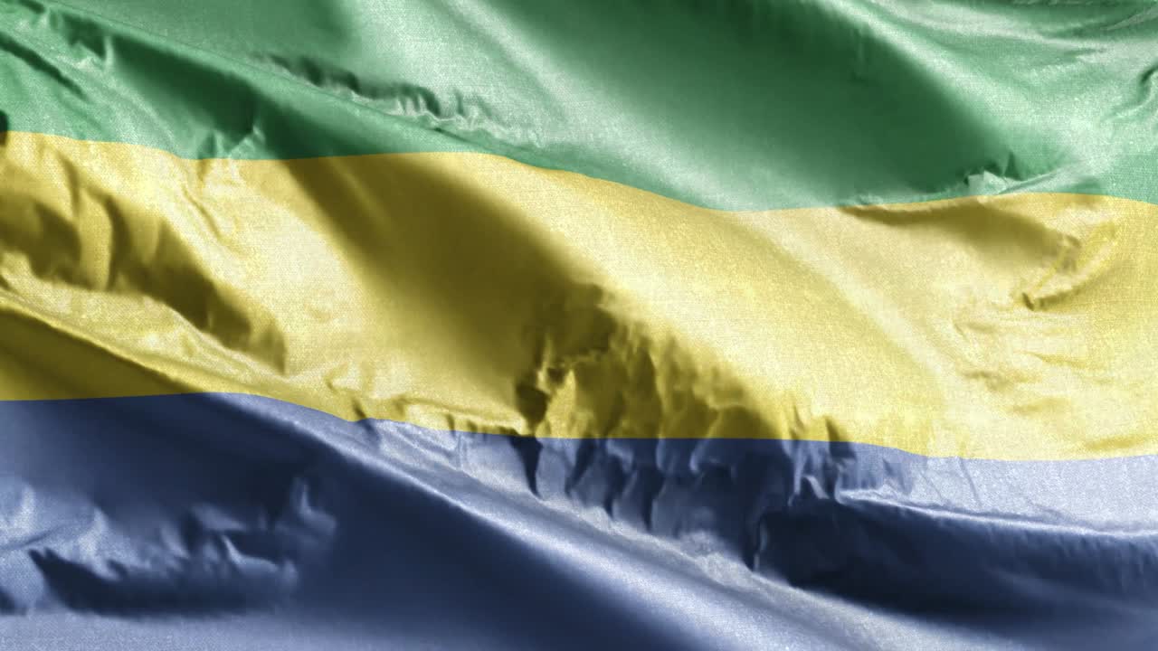 Bandiera tessile del Gabon che sventola al vento in loop. Stendardo gabonese che ondeggia nella brezza. Tessuto in stoffa. Sfondo a schermo intero. Loop di 10 secondi.