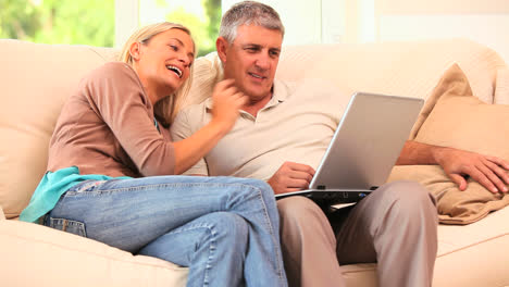 pareja usando la computadora portátil y riendo