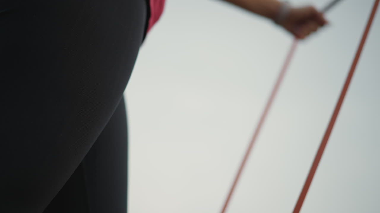Leggings And Resistance In Motion, Cinematic Slow Motion Of Hips Stretching Resistance Band Outside, Detailed Scene Of Hips Wearing Leggings While Pulling Resistance Band In Slow Motion Outside