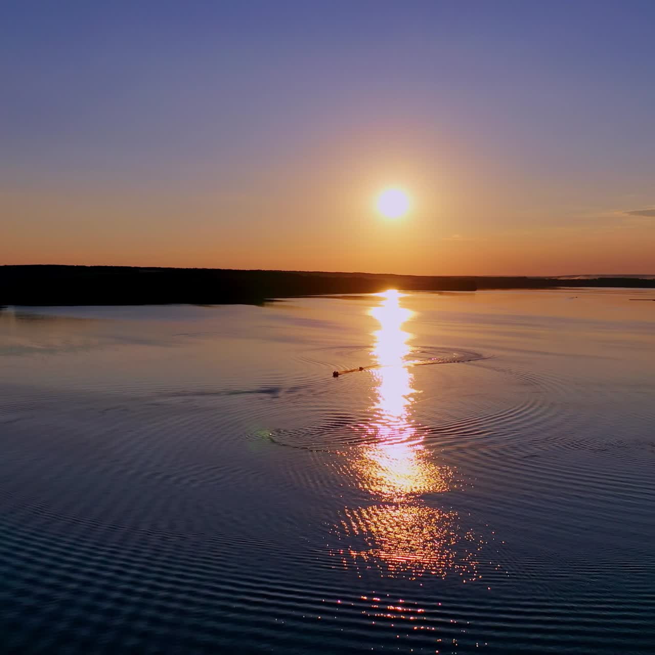 Beautiful sunset in nature. Sunny path reflects on the river in the evening. Amazing view on the lake against the setting sun.