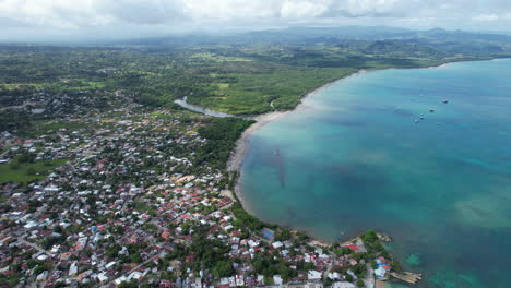 Impresionante-Vista-Aérea-De-La-Costa-Caribeña-En-Una-Ciudad-Con-Impresionantes-Colores-Y-Profundidad-De-Agua-Junto-A-Una-Playa-De-Arena