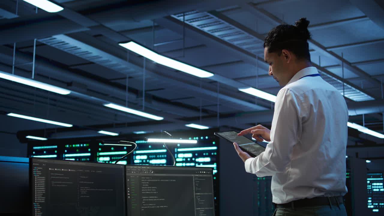 IT expert in server room tracking network traffic with tablet