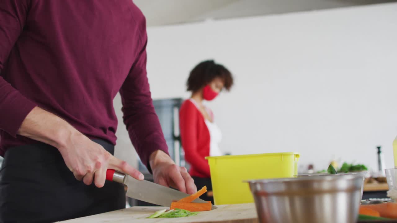 cocinero caucásico cortando zanahorias en la cocina